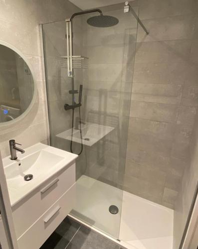 une salle de bain blanche avec une douche et un lavabo dans l'établissement La Terrasse, Hyper centre au calme avec stationnement, à Cherbourg en Cotentin