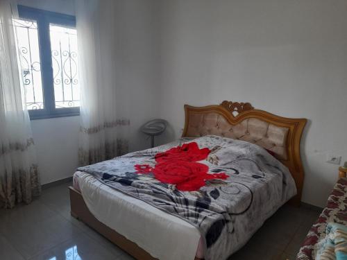 a red flower on a bed in a bedroom at appartement Cristiana 6 Midoun in Midoun