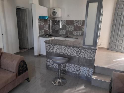 a kitchen with a sink and a counter with a stool at appartement Cristiana 6 Midoun in Midoun