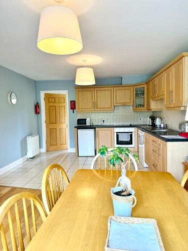 a kitchen and dining room with a wooden table at House No 3 Dingle Lispole Holiday Homes in Dingle