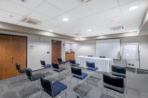 a meeting room with chairs and a table and a screen at City Express by Marriott Paraiso in Paraíso
