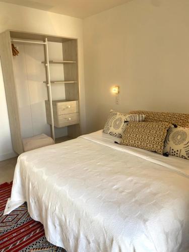 a bedroom with a white bed with pillows on it at SixTer in La Guérinière