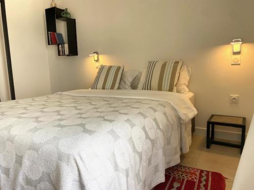 a bedroom with a white bed and a red rug at SixTer in La Guérinière
