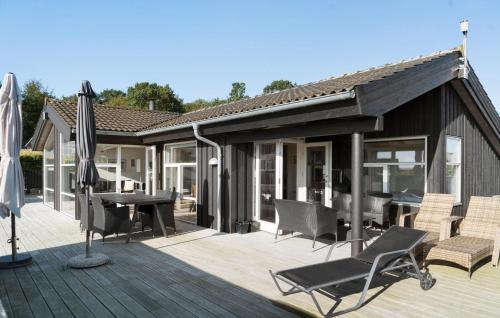 a deck with umbrellas and a table and chairs at Gorgeous Home In Haderslev With Wifi in Haderslev