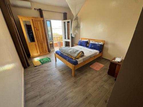 a bedroom with a bed and a wooden floor at Somone houses in Somone