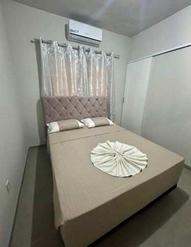 a bedroom with a large bed with a pink headboard at Hotel Monte Carlo in Dourados