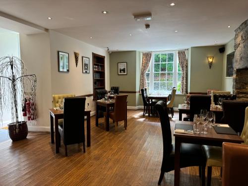 a restaurant with tables and chairs in a room at Aberdunant Hall in Porthmadog