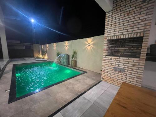 Una piscina con cascada en una casa por la noche. en Darocha Salinas, en Salinópolis