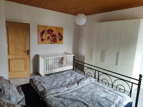 a bedroom with a crib and a bed in it at Ferienwohnung Bruckmühle in Wasserburg am Inn