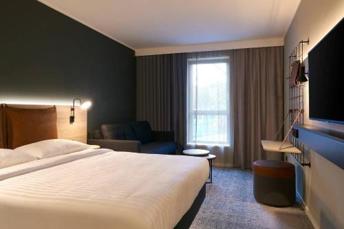 a hotel room with a large bed and a couch at Moxy Essen City in Essen