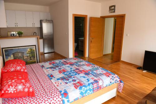 a bedroom with a bed with a quilt on it at Old House Bozovic in Nikšić