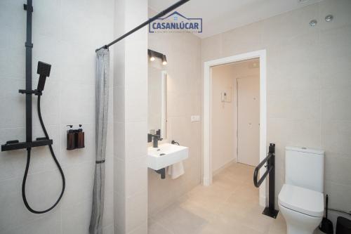 Un baño con ducha, inodoro y lavabo. en Sanlucar Centro - Apartamento 2, en Sanlúcar de Barrameda