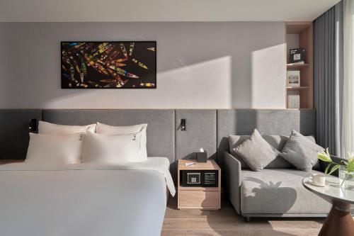 a hotel room with a bed and a couch at Adamas Boutique Hotel Nha Trang in Nha Trang