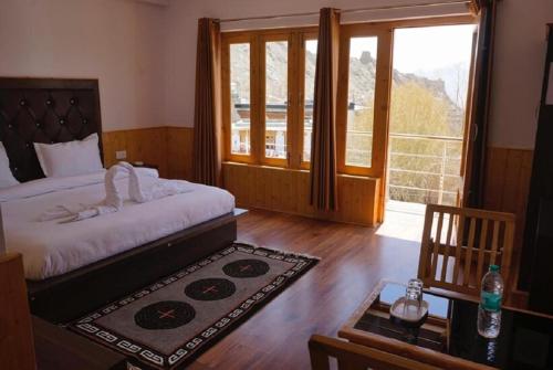 a bedroom with a bed and a large window at Jiwa lha Villa Ladakh by LexStays in Leh