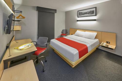 a bedroom with a bed and a desk and a desk at City Express by Marriott Monterrey Norte in Monterrey