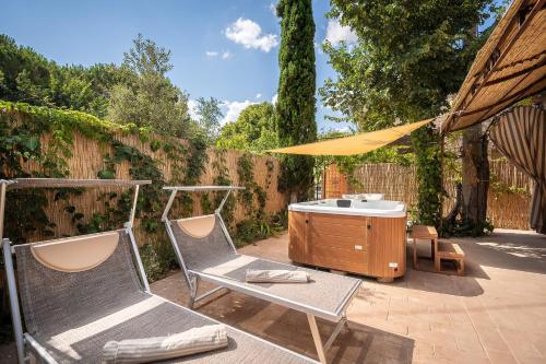 a patio with two chairs and a tub and a yellow umbrella at Fontarcella, Heart & Roots in Petrignano sul Lago