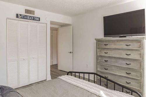 a bedroom with a dresser and a flat screen tv at Turtle View Villa in Hilton Head Island