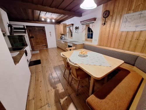 a kitchen with a wooden table and a wooden floor at Ferienhaus Hinterhabneralm in Petersberg