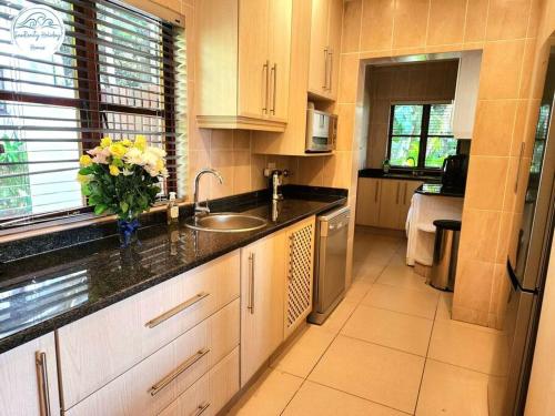 a kitchen with a sink and a vase of flowers on the counter at Villa P16 - Selborne Golf Estate in Pennington