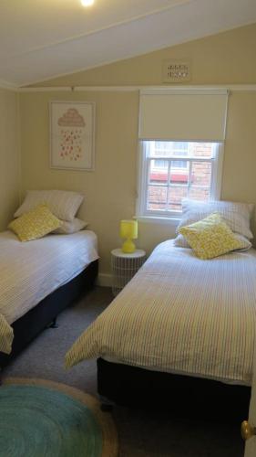 a bedroom with two beds and a window at Stylish country cottage in central Orange in Orange