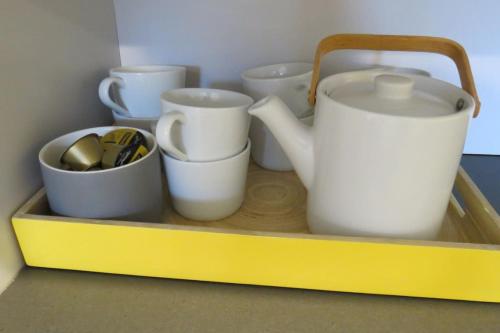 a shelf with cups and utensils on it at Stylish country cottage in central Orange in Orange