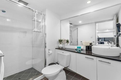 a white bathroom with a toilet and a sink at City Life 2BR Apt with Pool,Gym, Sauna, Carbay in Perth