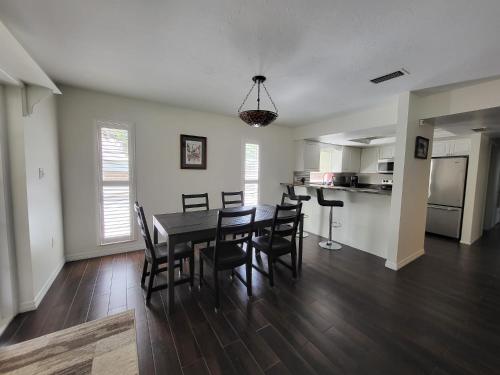 a dining room and kitchen with a table and chairs at Comfortable home, heated salt-cell pool, 10 min to beach in Sarasota