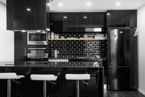 a kitchen with black cabinets and a black counter top at Brilliant 2BR Apartment in Belconnen - Hosted by Canstay in Belconnen