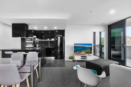 a kitchen with a glass table and white chairs at Brilliant 2BR Apartment in Belconnen - Hosted by Canstay in Belconnen