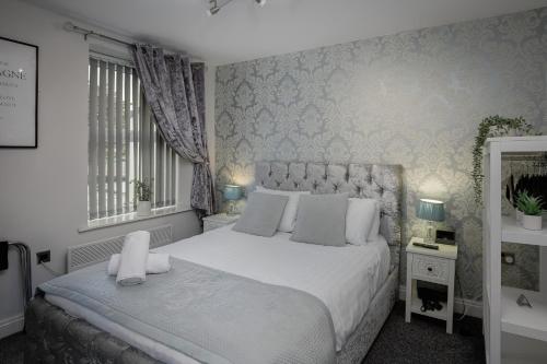 a bedroom with a large white bed and a window at The Place by Sasco in Blackpool