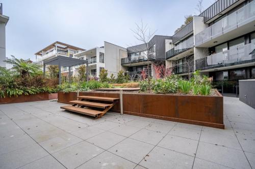 a park with a bench in front of a building at Kingston Foreshore Apt - Hosted by Canstay in Kingston 