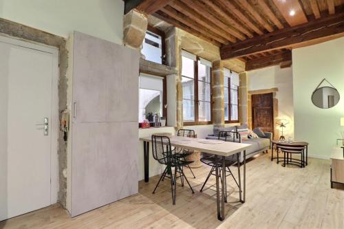 une cuisine et un salon avec une table et des chaises dans l'établissement Le Trois Maries - Cozy Apartment - Lyon 5th, à Lyon