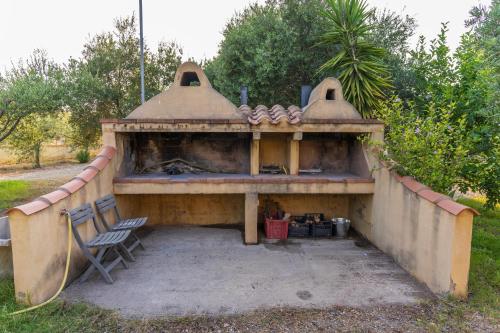 an outdoor fireplace with a chair in front of it at Armandiola in Cardedu