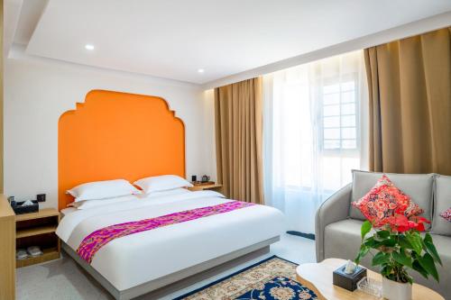 a bedroom with a large bed and a chair at 红柳花天台花园民宿Red Willow Flower Hotel in Kashgar
