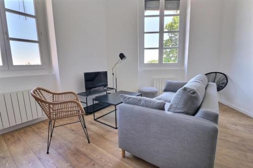 un salon avec un canapé et une chaise dans l'établissement Le Quai d'Or - Apartment for monthly rental - Lyon 4th, à Lyon