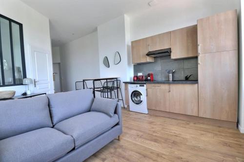 un salon avec un canapé et une cuisine dans l'établissement Le Quai d'Or - Apartment for monthly rental - Lyon 4th, à Lyon