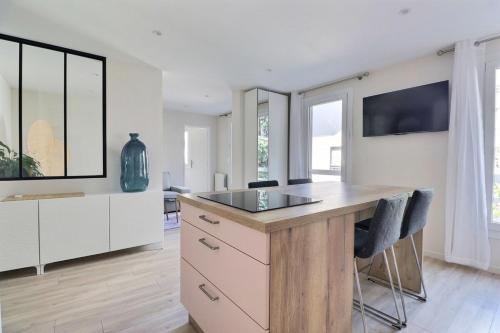 une cuisine avec des placards blancs et un comptoir avec des chaises dans l'établissement The Monplaisir - Magnificent T2 apartment - Lyon 8th, à Lyon