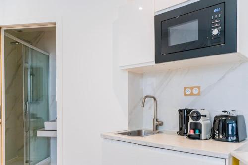 une cuisine avec un évier et un micro-ondes dans l'établissement Luxurious Apartment with Stylish Design and Comfort - 104, à Paris