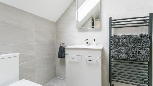 a white bathroom with a sink and a mirror at The Nook in Valley