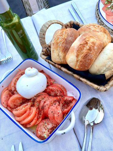 a table with a tray of bread and a dish of tomatoes at Hacienda el Tarajal in Priego de Córdoba
