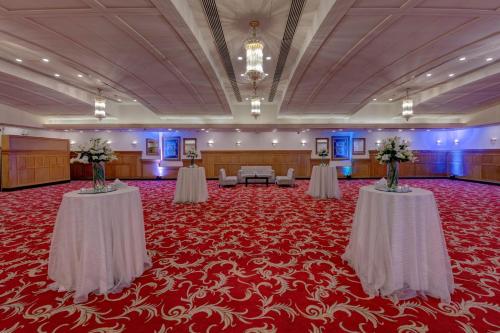 a large room with two tables and chairs on a red carpet at Islamabad Marriott Hotel in Islamabad