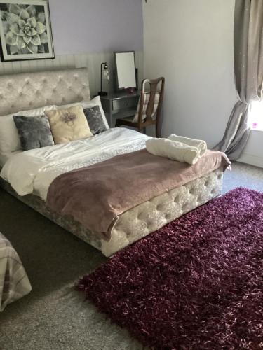 a bedroom with a large bed with a purple rug at The lavender house 513 halliwell rd bolton bl18db in Bolton