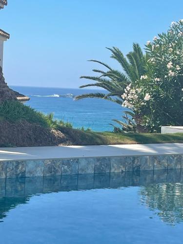 a swimming pool with the ocean in the background at Tierratlanta Suites in Zahara de los Atunes