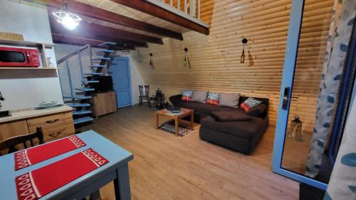 a living room with a couch and a table at Cabana Vanatorilor A Frame Blue in Văliug