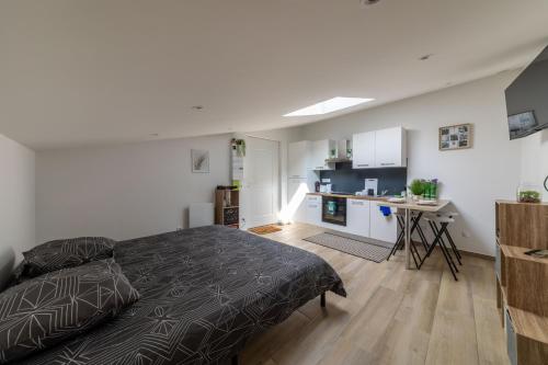 une chambre avec un lit et un bureau dans une pièce dans l'établissement Logement Insolite Ancienne Soue à Cochons Rénovée, à Casteljaloux