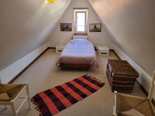 Cette chambre mansardée comprend un lit et un tapis. dans l'établissement Les Toits du Tonnelier - 64 m2 - situation plein centre médiéval - sauna - 2 garages, à Kaysersberg