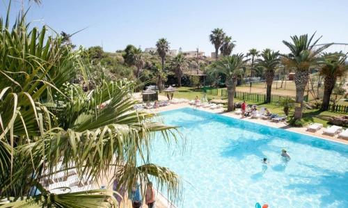 a large swimming pool with people in a resort at Sporting Club Village in Mazara del Vallo