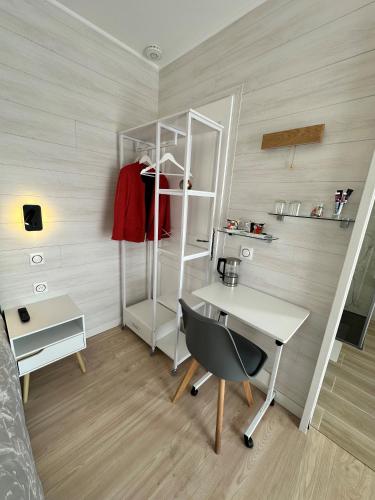 a room with a desk and a shelf and a bed at Le mas des anges in Soussans