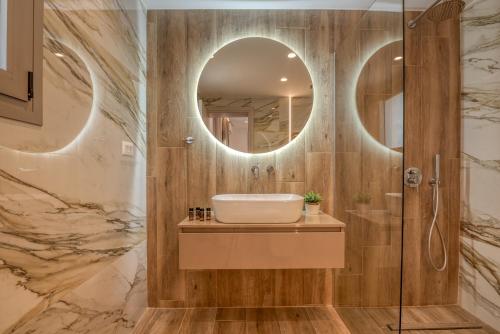 a bathroom with a sink and a mirror at Kiwi Boutique Studios in Kissamos