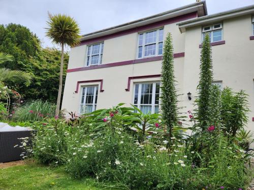 a house with flowering plants in front of it at Rose Court Holiday Apartments in Torquay